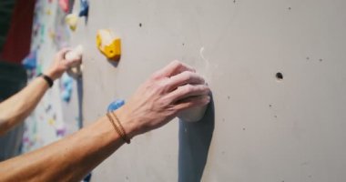 Genç bir adam güvenlik ipleri olmadan duvarlara tırmanıyor.