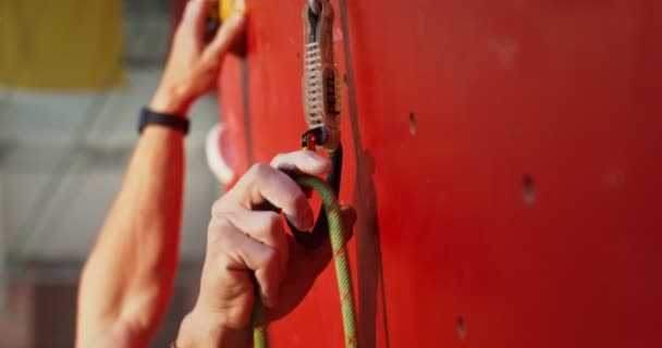 Close-up de fixar um cordão para os ganchos em uma parede de escalada — Vídeo de Stock