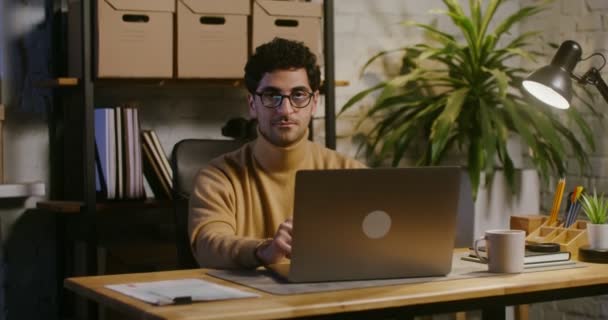 Junger Mann blickt im Büro direkt in die Kamera — Stockvideo