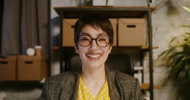 Fiatal nő mosolyog néz egyenesen a kamera előtt ül a laptop — Stock videók