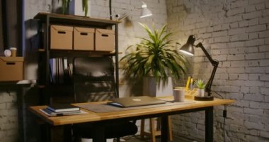 Yarı kapalı bir dizüstü bilgisayar modern bir ofiste, insanların olmadığı bir masada yatıyor.