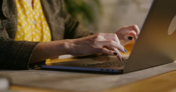 Eine junge Frau mit ernstem Blick tippt in einem modernen Büro auf einem Laptop — Stockvideo