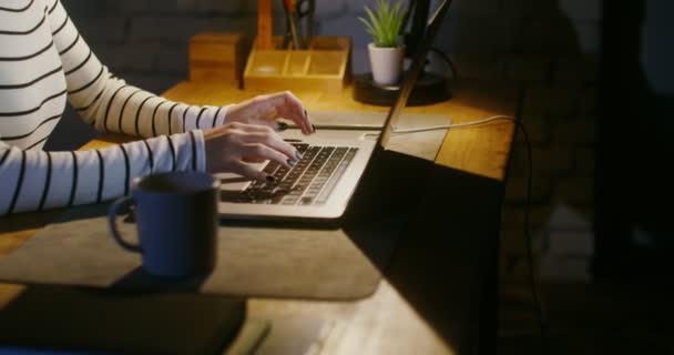 Kobieta pisząca na laptopie, siedząca przy stole w biurze, zbliżenie, bez twarzy — Wideo stockowe