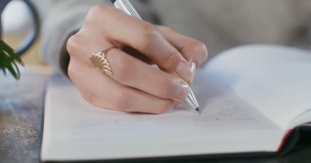 Zbliżenie pisma długopisem w notatniku kobieca ręka — Wideo stockowe
