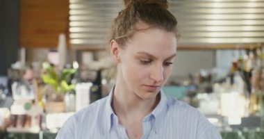 Bir kafede oturan, yakından bakan genç bir kızın yüzü.