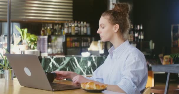 Junge Geschäftsfrau öffnet Laptop und beginnt im Café sitzend zu arbeiten — Stockvideo