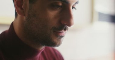 Genç adam kahve aromasını içine çekiyor ve bir yudum alıyor, profil üzerinde yakın çekim.