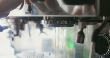 Bir kadın kahve makinesine kahve kabı yerleştiriyor.