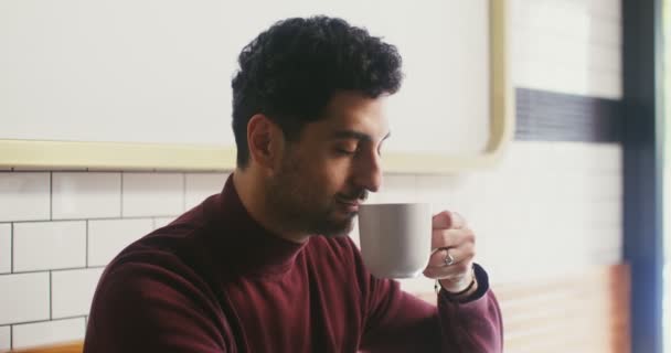 Jeune homme inhale arôme de café et prend une gorgée — Video