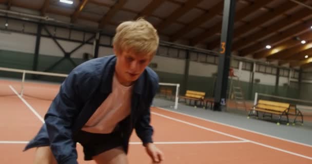 Ein junger Mann fängt einen Tennisball nach dem anderen mit den Händen und springt schnell — Stockvideo