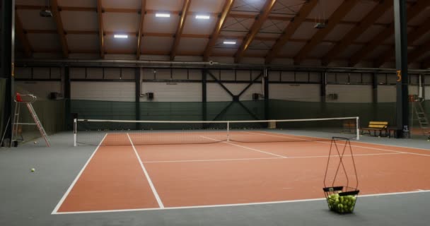 Een lege tennisbaan met een staande mand vol tennisballen — Stockvideo