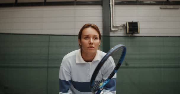 Una joven está esperando intensamente el primer lanzamiento de pelota de tenis por un oponente — Vídeos de Stock