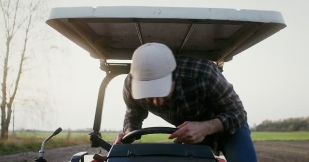 Vista frontal de cerca de un conductor de tractor sentado al volante de una máquina — Vídeos de Stock
