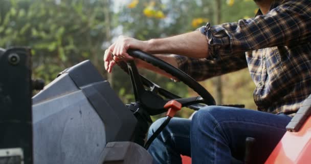 A young man turned off tractor engine and got out of it, having finished work — Stock Video