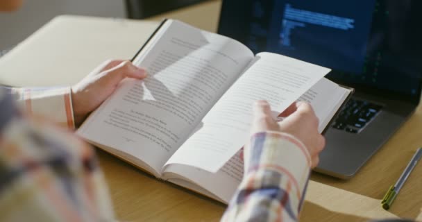 Seorang pria ternyata daun buku duduk di meja, close-up — Stok Video