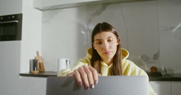 Una joven abre una laptop, se pone auriculares y empieza un video chat — Vídeos de Stock