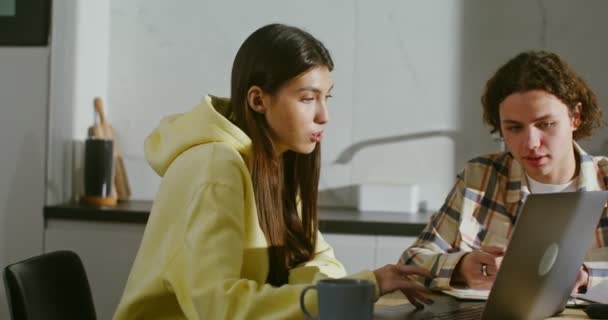 Young couple are engaged at home with books and an open laptop — 图库视频影像