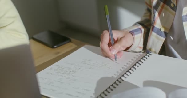 ノートにノートを作る人の手のクローズアップ,顔は見えません — ストック動画
