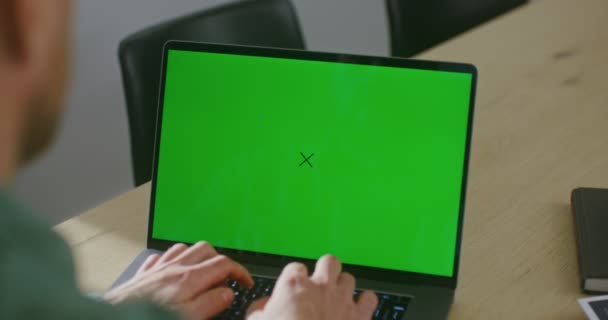 一个年轻人正在用绿色屏幕、彩色键和复制空间的笔记本电脑上打字 — 图库视频影像