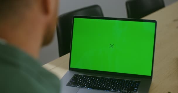 Młody mężczyzna video czat na laptopie z zielonym ekranem, przestrzeń kopiowania — Wideo stockowe