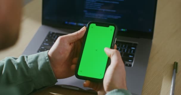En ung man rullar den gröna skärmen på en mobiltelefon, kopiera utrymme — Stockvideo