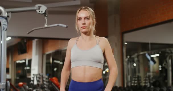 Seorang wanita melakukan pemanasan sebelum memulai kelas pada simulator di gym — Stok Video