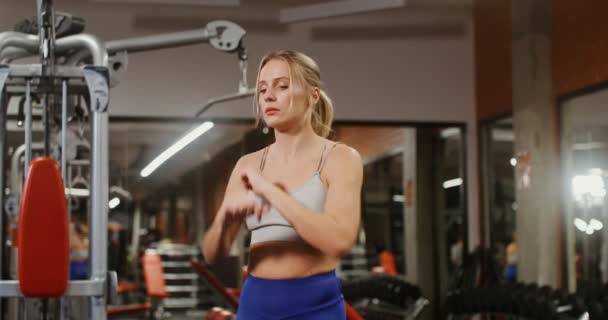 A woman is doing a warm-up before starting classes on the simulators in gym — Stock Video