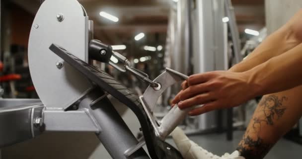 A young man is engaged in an exercise machine, shaking his chest muscles — Stock Video