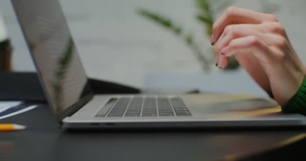 Foto close-up dari wanita tangan mengetik pada keyboard laptop saat duduk di kantor — Stok Video