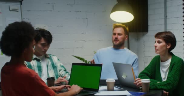 Young colleagues work in team, using laptop and communicating, sitting in office — Wideo stockowe