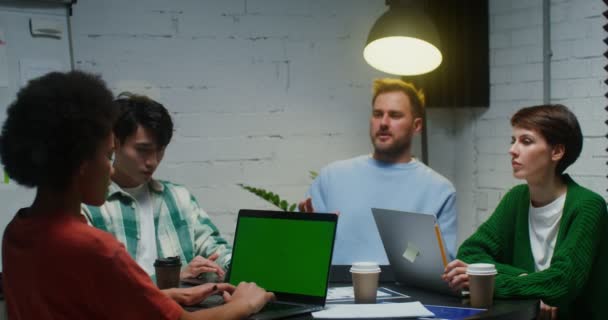 Jóvenes colegas trabajan en equipo, usando laptop y comunicándose, sentados en la oficina — Vídeo de stock