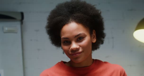 Young African American woman turns her head and looks straight into the camera — 图库视频影像