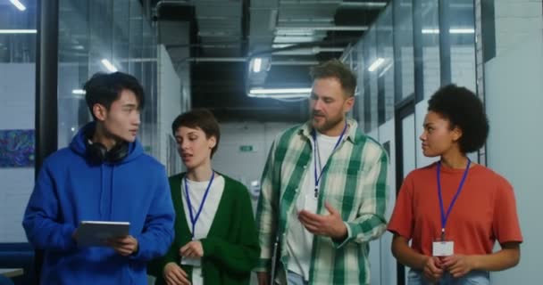 Een groep ondernemers loopt langs het kantoorcentrum, onder elkaar pratend — Stockvideo