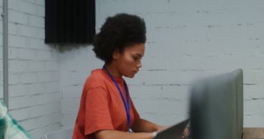 Bir erkek ve bir kadın laptoplarda çalışıyor, bir ofiste çalışma masasında oturuyorlar.