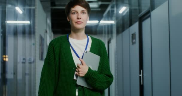 Une femme d'affaires avec une tablette dans les mains, marchant le long du couloir dans le bureau — Video