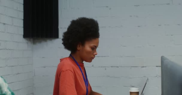 A man and woman work at laptops, sitting at one work desk in a office — Video Stock