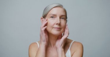 Makyajsız bir son sınıf modeli kameraya bakıyor.