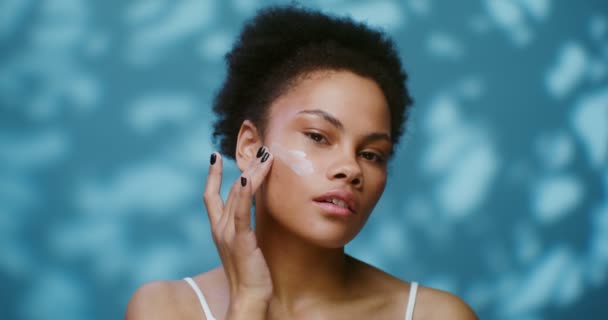 年轻性感的非洲裔美国女人在脸上涂润肤霜 — 图库视频影像