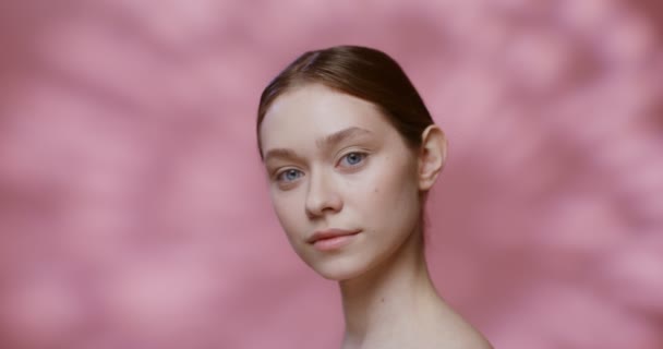 Ung kaukasisk modell utan makeup leende tittar på kameran — Stockvideo