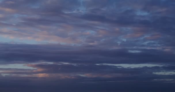 Cielo nublado al atardecer. Reflejos rosados en las nubes flotando a través del cielo — Vídeos de Stock