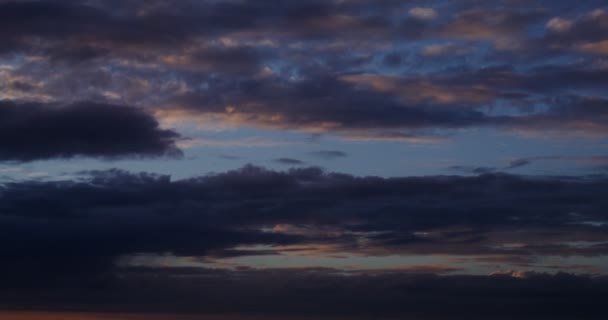 Облачное небо на закате. Розовые отражения на облаках, плавающих по небу — стоковое видео