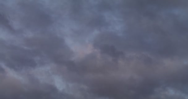 Niebo pokryte ciemnymi chmurami z różowymi odbiciami zachodzącego słońca — Wideo stockowe