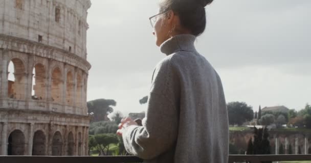 Una donna ammira il Colosseo, in piedi sul ponte di osservazione in una giornata di sole — Video Stock