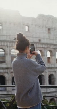 Kolezyum yakınlarındaki bir cep telefonuyla Roma 'nın fotoğraflarını çeken bir kadın.