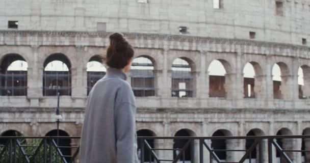 Una mujer toma fotografías de lugares de interés de Roma en un teléfono móvil cerca del Coliseo — Vídeos de Stock