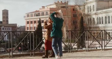 İki kadın turist, bir cep telefonuyla gözlem güvertesinde fotoğraf çekiyor.