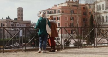İki kadın turist Avrupa 'nın bir şehrinde bir gözlem güvertesinden geziyorlar.