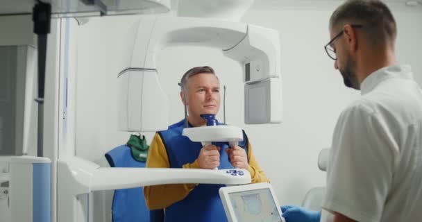 Preparing for a dental scan. Patient inside a panoramic 3D dental scanne — Stock Video