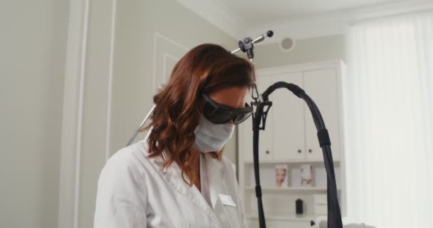 Een dermatoloog arts maakt een laserbehandeling procedure voor een patiënt huid — Stockvideo