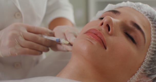 Un cosmetólogo inyecta una cara de paciente con preparaciones médicas — Vídeo de stock